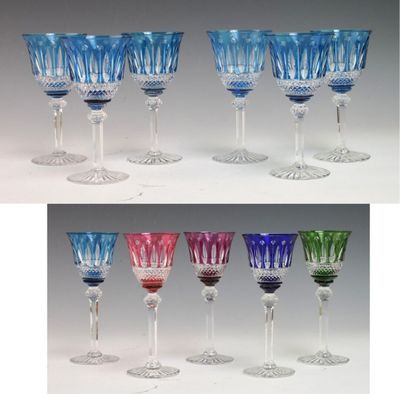 several different colored wine glasses sitting next to each other on a table