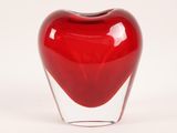 a glass vase with a red heart inside of it