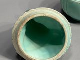 two green vases sitting next to each other on a table