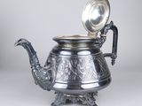 an antique silver teapot with a silver lid and a silver handle