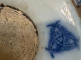 a close up of a blue and white vase with a bird on it