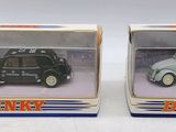 two toy cars are in a box on a white surface