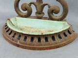 an old iron grate with a bowl on top of it