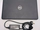 dell laptop computer with power cord and charger sitting on a table
