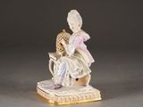 a figurine of a woman sitting on a chair