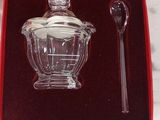 a glass teapot and spoon in a red box