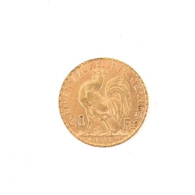 une pièce d'or représentant un coq sur un fond blanc