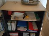 a shelf with many files and a basket with scissors