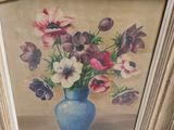 un tableau représentant des fleurs dans un vase bleu accroché au mur