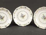 trois assiettes à motifs floraux posées sur une table