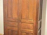 a wooden armoire in the corner of a room