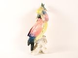 a figurine of a parrot sitting on top of a rock