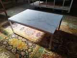une table basse au plateau en marbre posée sur un tapis dans un salon
