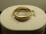 une bague en or posée sur une boîte blanche