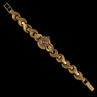 a close up of a gold bracelet on a black background
