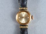 an image of a wrist watch with a gold dial