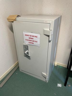 a safe box with a sign on it in the corner of a room