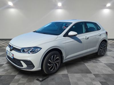 une Volkswagen Polo blanche garée dans une pièce au sol carrelé