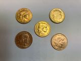 quatre types différents de pièces d'or sur une surface blanche