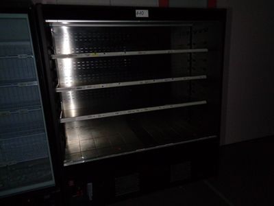 an empty refrigerator in a dark room next to a freezer