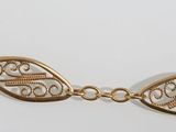 a close up of a gold necklace on a white background