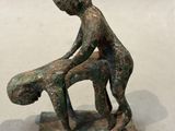 bronze figurine of a boy sitting on a bench with a dog