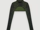 a woman wearing a green and black top with leopard print on it