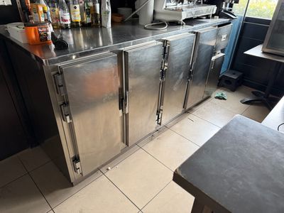 a stainless steel counter with bottles on top of it