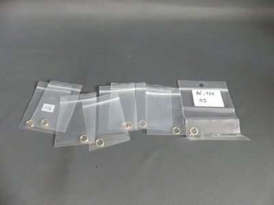 quatre sachets de sacs en plastique munis d'anneaux métalliques posés sur une table