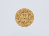 a gold coin on a white surface with a white background