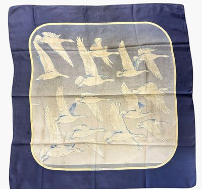 une photo d'un foulard en soie bleu et jaune orné d'oiseaux