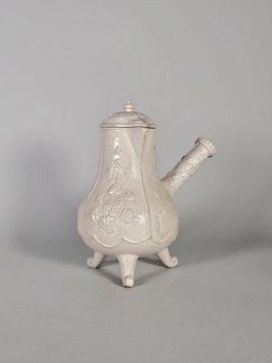 une image représentant une théière blanche posée sur une table
