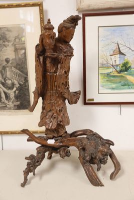 a statue of an angel holding a bird on a tree branch