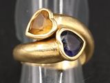 une image représentant une bague en or ornée de deux cœurs et d'un saphir