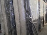 de nombreux matelas emballés dans du plastique dans un entrepôt