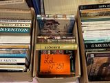 Des cartons remplis de livres sont empilés sur une table dans une pièce