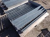 a metal grate laying on the ground next to a fence