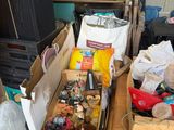 Des cartons contenant des objets divers sont posés sur une table dans une pièce encombrée