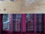 many forks and spoons in a box on a table