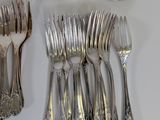 a lot of forks and spoons that are on the table