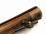 an old rifle with a wooden barrel and metal handle on a white surface