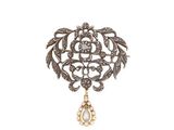 un gros plan d'une broche ornée d'un pendentif en forme de larme