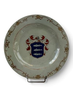 a white plate with a blue and red coat of arms on it
