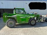 a picture of a green tractor parked in front of a building