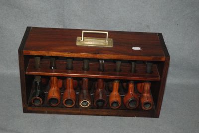 une vitrine en bois contenant plusieurs types de pipes