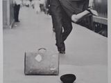 a black and white photo of a woman running with a suitcase