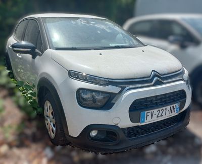 a small white car parked on the side of the road