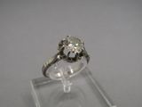 a close up of a diamond ring sitting on top of a clear display case