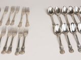 many forks and spoons laid out on the table