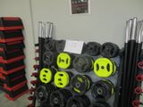 une photo d'une salle de sport avec un rack rempli d'haltères